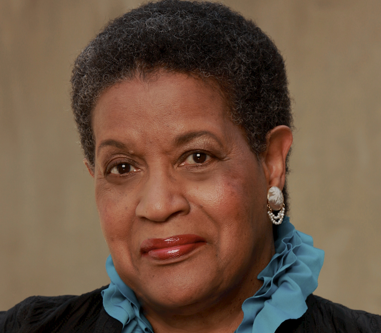 A photo of Myrlie Evers wearing a blue ruffled collared shirt.